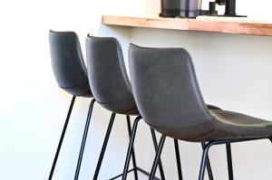 a row of black chairs sitting next to a wall at Dos Hermanas Casita 4, 5 & 6 Downtown Courtyard in Santa Fe