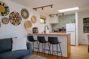 a kitchen and living room with a counter and stools at Dos Hermanas Casita 4, 5 & 6 Downtown Courtyard in Santa Fe