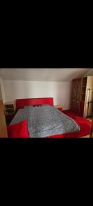 a bedroom with a bed with a red bedspread at Apartment Bistrik in Sarajevo