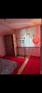 a bedroom with a bed and a window and a red rug at Apartment Bistrik in Sarajevo