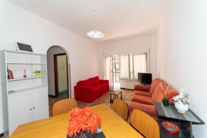 Una sala de estar con un sofá rojo y una mesa. en Ampio appartamento Albissola Marina, en Albissola Marina 20 fotos más