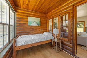a bedroom with a bed in a log cabin at Willow Heaven - Lakefront Cabin Escape in Madill