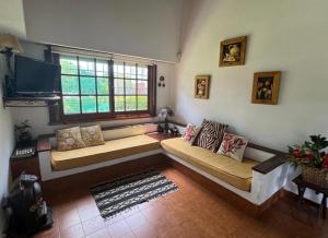 Una sala de estar con un sofá y una ventana. en La casita en la playa, en Villa Gesell