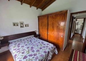 Un dormitorio con una cama y un armario de madera. en La casita en la playa, en Villa Gesell