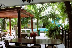 a patio with a table and chairs and a pool at Santa Mônica Palace Hotel in Corumbá