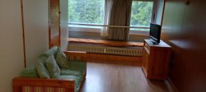a living room with a couch and a tv and a window at Appartamento Artuik Marilleva 1400 in Marilleva