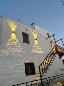 ein weißes Gebäude mit Fenstern und einer Treppe in der Unterkunft Plagia Luxury Suites in Skyros