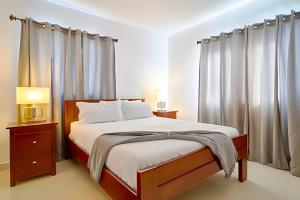 a bedroom with a large bed with curtains at Villa x 2|Downtown Punta Cana|Pool|Hammock + BBQ in Punta Cana +45 photos
