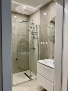 a bathroom with a shower and a sink at Laguna Beskidów Apartament Bosko z sauną i siłownią in Zarzecze
