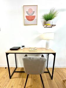 einen Schreibtisch mit einem Stuhl und einer Lampe in der Unterkunft Centre-Ville, 5 min de la Plage, parking, piscine in La Grande-Motte + 11 Fotos