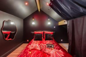 ein Schlafzimmer mit einem roten Bett, auf dem eine Person liegt in der Unterkunft Nid d'amour romantique in Corbeil-Essonnes + 37 Fotos