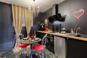 eine Küche mit einem Tisch mit roten Stühlen und einer Theke in der Unterkunft Nid d'amour romantique in Corbeil-Essonnes