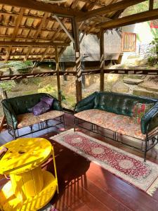 a living room with a green couch and a yellow table at Pousada Murmúrio das Águas in São Francisco Xavier