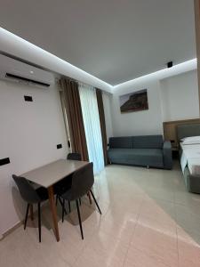 a room with a table and a bed and a couch at Gael Apartment in Berat