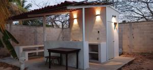a outdoor kitchen with a table next to a wall at Villa Prix in Hunucmá +1 photo