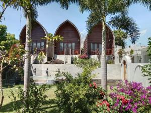 ein Haus mit zwei Bogenfenstern und Palmen in der Unterkunft Volcano Retreat in Kubupenlokan