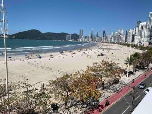 a beach with people on the sand and the ocean at Apartamento fantástico com linda vista lateral do mar in Balneário Camboriú