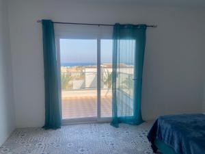 Un dormitorio con una ventana con vista al mar. en Evasion a El hawarea, en El Haouaria