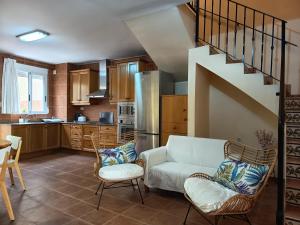 a living room with a couch and chairs in a kitchen at La Senia in Moncófar