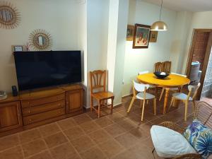 a living room with a television and a table with chairs at La Senia in Moncófar