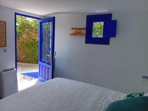 a bedroom with a bed and a blue door at El Portal, 12 mins from Sitges in Olivella