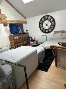 a bedroom with a bed and a clock on the wall at Jolie duplex T2 avec terrasse in Saint-Jean-de-Gonville +11 photos