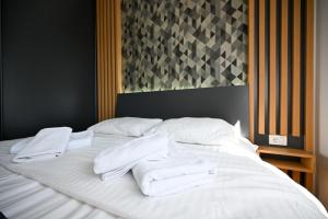a bed with white towels on top of it at Black Diamond Zlatibor in Zlatibor