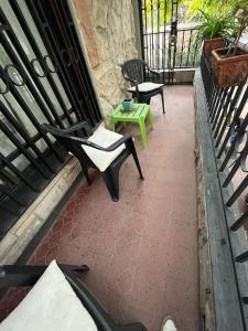 ein Balkon mit zwei Stühlen und einem Tisch in der Unterkunft SUITE FAMILIAR EN CENTRO CIUDAD DE MENDOZA COCHERA DISPONiBLE in Barraquero