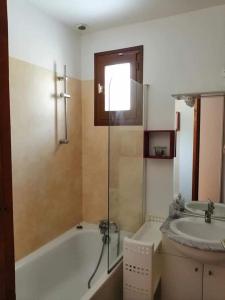 ein Badezimmer mit Badewanne und Waschbecken in der Unterkunft Appartement à proximité de Ax les thermes in Ignaux