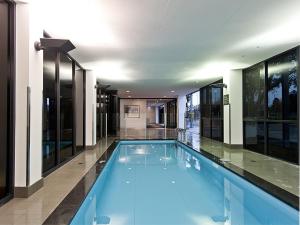 a large swimming pool in a building with windows at Quest Rockingham in Rockingham