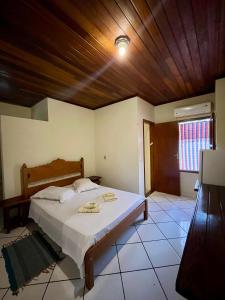 a bedroom with a large bed with a wooden ceiling at Pousada Murmúrio das Águas in São Francisco Xavier