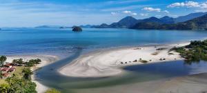 an aerial view of a beach with mountains and the ocean at Chalés Villa do Mar in Ubatuba
