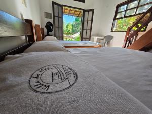 a bed in a room with a bedspread on it at Chalés Villa do Mar in Ubatuba +44 photos