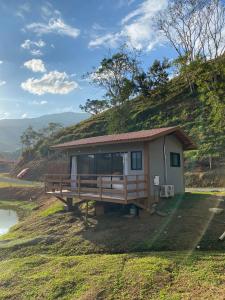 a small house on a hill with a grassy slope at Fazenda - Lago in São José dos Campos