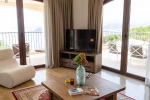 a living room with a television and a vase with flowers on a table at Zorka in Budva