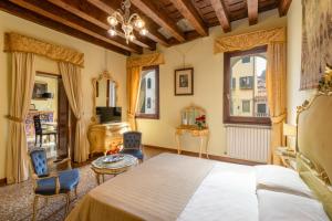 a bedroom with a bed and chairs in a room at B&B Luxury San Firmino Canal View in Venice +59 photos