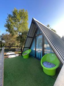 a house with two large green toilets on the grass at Croft Yelagiri - glamping stay in Yelagiri