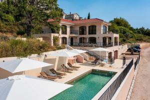 a large house with a swimming pool and umbrellas at Zorka in Budva