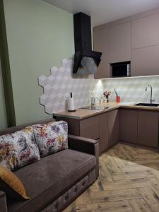 Una sala de estar con un sofá y una cocina. en ЖК Bridge, en Rivne