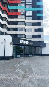 Un edificio con una torre de puente delante de él. en ЖК Bridge, en Rivne