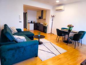 a living room with a blue couch and a table at La Riva Apartment Sea View in Rovinj