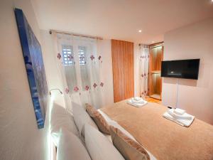 a bedroom with a couch and a television in it at La Riva Apartment Sea View in Rovinj