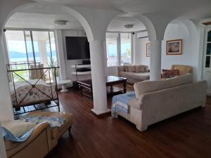 a living room with two couches and a television at Casa Tortugas Manzanillo in Manzanillo