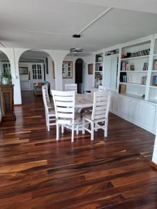 a dining room with a table and white chairs at Casa Tortugas Manzanillo in Manzanillo +14 photos
