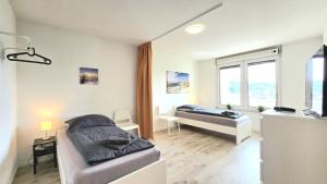 ハーゲンにあるModern 3-Room Apartment with Balcony & Free Parking & Free Wi-Fi in Hagen - HA03のベッド2台と机と窓のある寝室