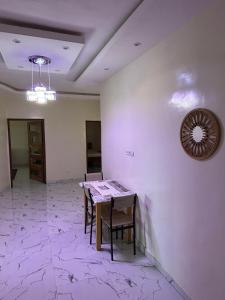 a room with a table and chairs and a clock on the wall at Immeuble Houleye Moctar Sow in Dakar