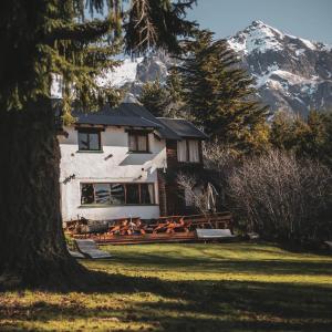a white house with a mountain in the background at Hosteria Las Cartas in San Carlos de Bariloche