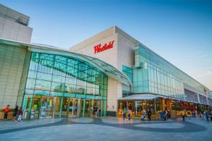a large building with people walking in front of it at London Acton Central House in London