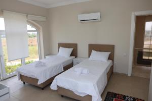 two beds in a room with a window at Pine Golf Village Belek in Belek +14 photos