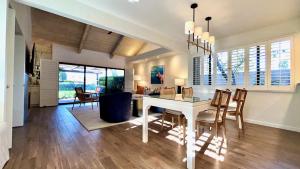 a kitchen and dining room with a white table and chairs at Racquet Club Retreat Modern Luxe Living in a Peaceful Desert Escape – managed by Greenday in Rancho Mirage